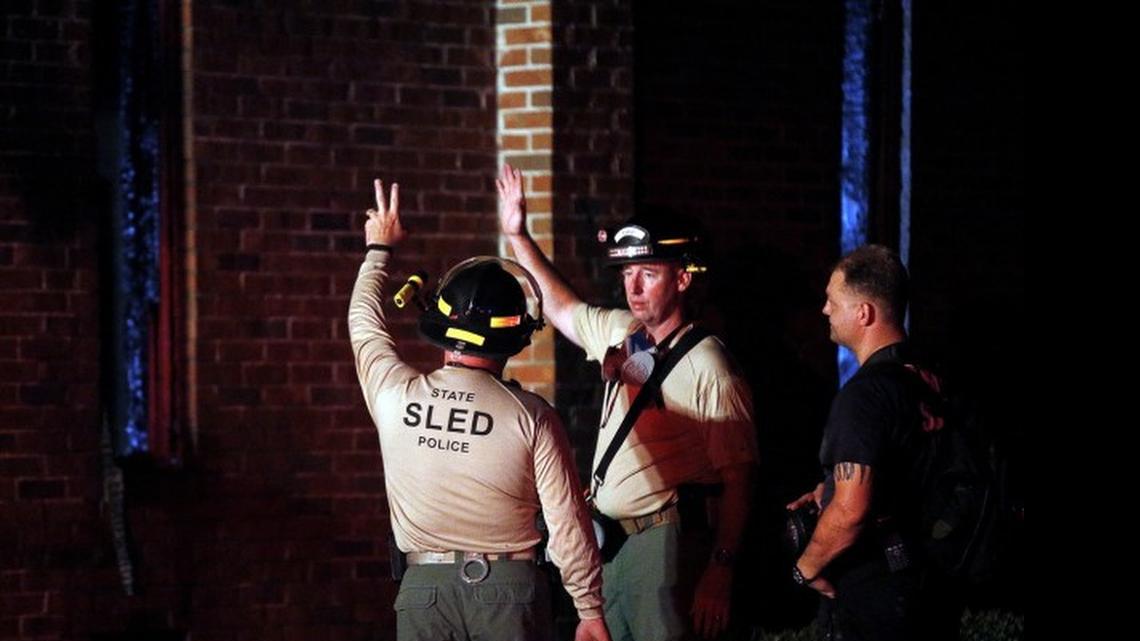 Members of the South Carolina Law Enforcement Division talk as they examine the remains of a fire at Mount Zion African Methodist Episcopal church, early Wednesday, July 1, 2015, in Greeleyville, S.C. The African-American church, which was burned down by the Ku Klux Klan in 1995, caught fire late Tuesday night.