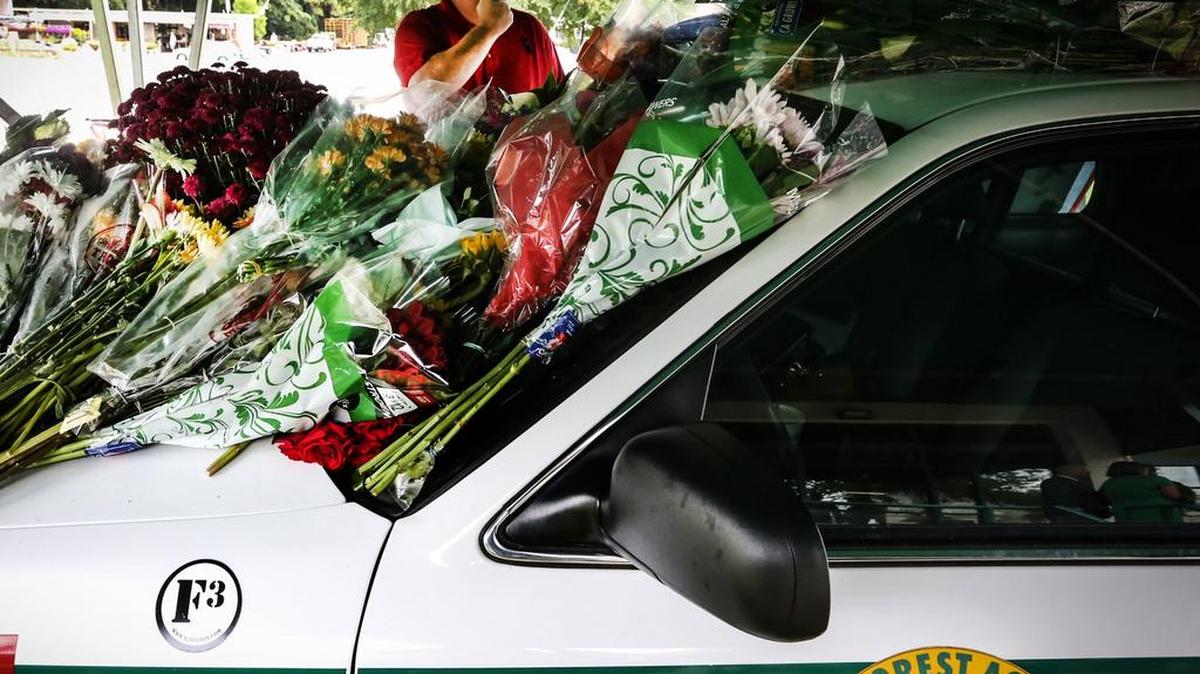 
Retired Forest Acres Police Officer Jay Lewis pays respects to his former collegue, Greg Alia. Forest Acres community members brought flowers to the police department to pay respects to Officer Greg Alia, 32, who was shot to death after three officers responded to a report of a suspicious person Wednesday at Richland Mall.
