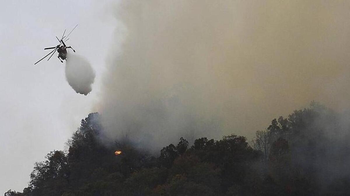 Crews work a wildfire near Lake Lure Friday, Nov. 11. State transportation officials say the wildfire near Lake Lure has forced the immediate closing of U.S. 64/74A and N.C. 9 in Rutherford County.