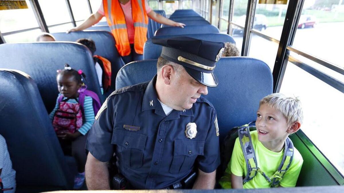 FILE PHOTO. Lexington Police Chief Mark Barnard talked with 6-year-old Avery Cooper as they rode the bus on the first day of school for Fayette County schools in Lexington, Ky., Wednesday, August 10, 2016.