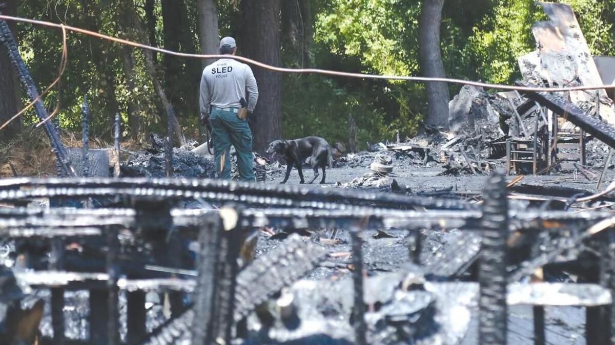 A SLED agent and his arson dog check through the rubble of The Compass restaurant in 2016 after a fire destroyed the business.