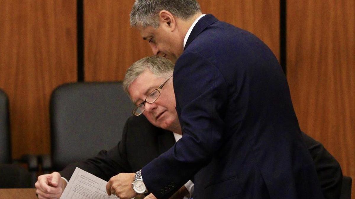 Former S.C. House Majority Leader Jim Merrill goes over a document with his attorney, state Democratic representative Leon Stavrinakis of Charleston, before court began Friday.