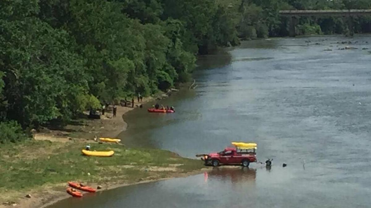 Rescue workers search the waters of the Congaree River on Sunday after a man went missing while trying to swim across the river with three other people.
