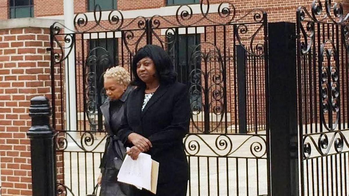 
Benita Dinkins-Robinson, right, walks outside the federal courthouse during her trial in March. She was found guilty of embezzling from the charter school where she served as principal.
