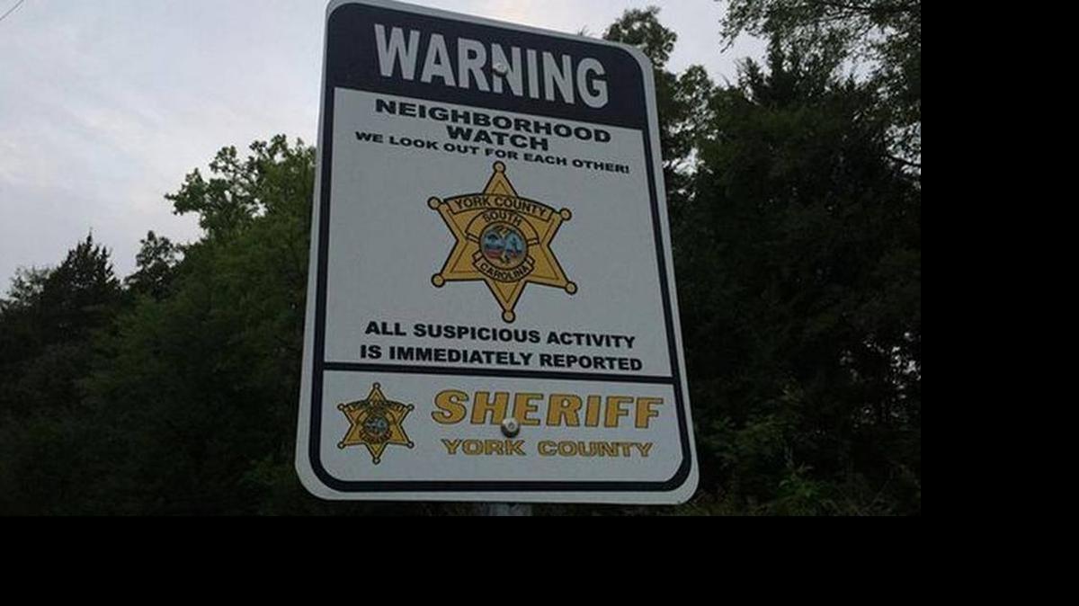 
A neighborhood watch sign in the area where the bodies of two men were found in a burning truck.

