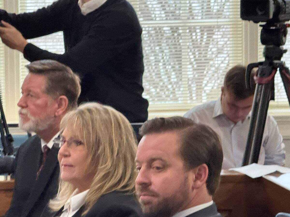 Former Colleton County court clerk Becky Hill sits with her defense lawyer, Will Lewis (right) and her husband, Tommy Hill, in the Calhoun County courthouse awaiting her hearing Monday, Dec. 8, 2025.