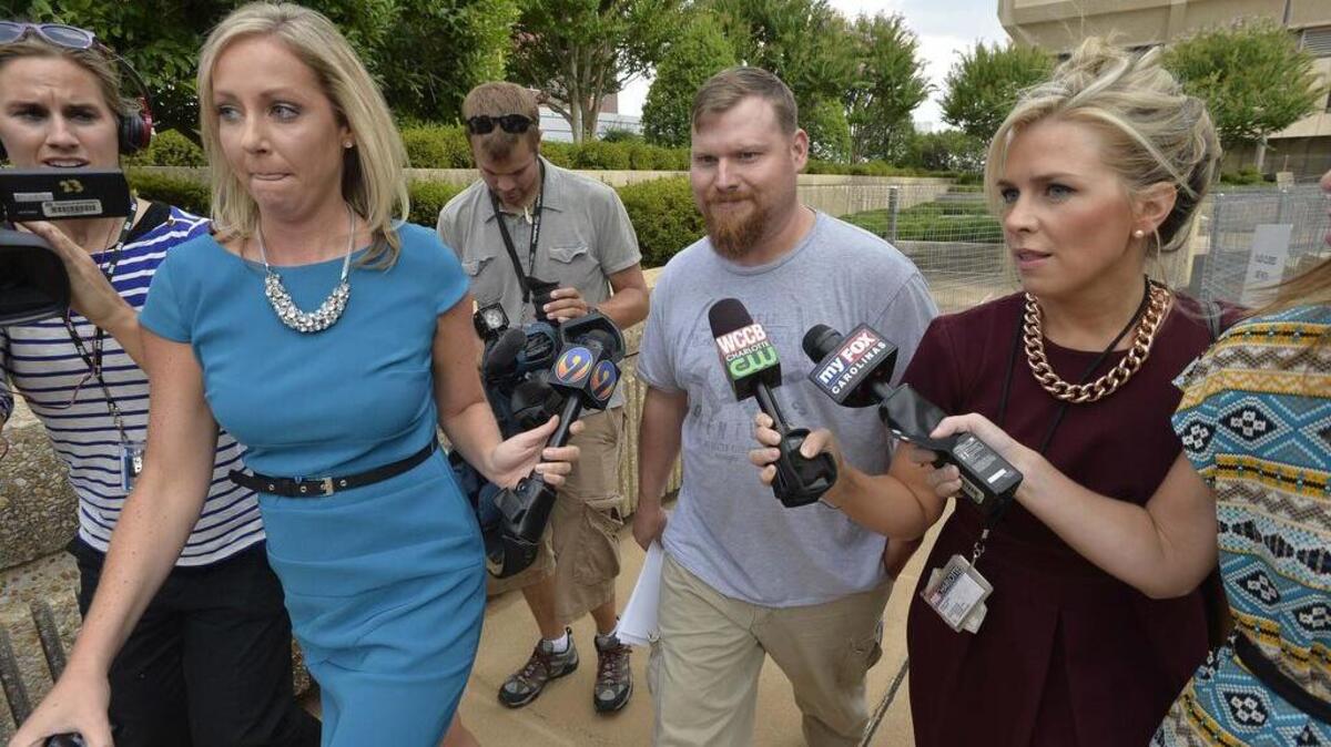 Surrounded by reporters, Sandy Parsons leaves the federal courthouse in Winston-Salem in 2014 after he and his wife Casey Parsons were arrested on fraud charges.