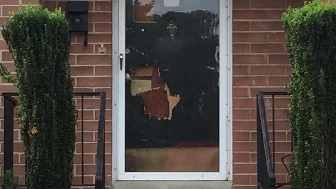 The front door at 3905 Rosewood Drive, with a hole bashed in near the lock.