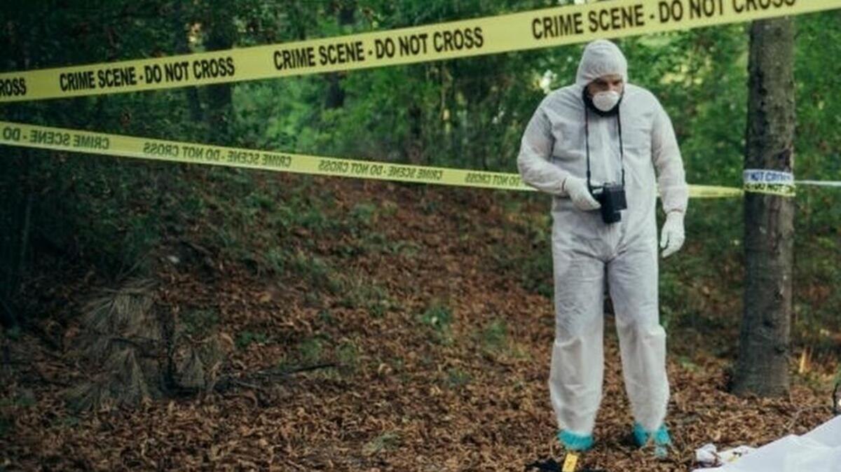 Detective and forensics on murder crime scene collecting evidence