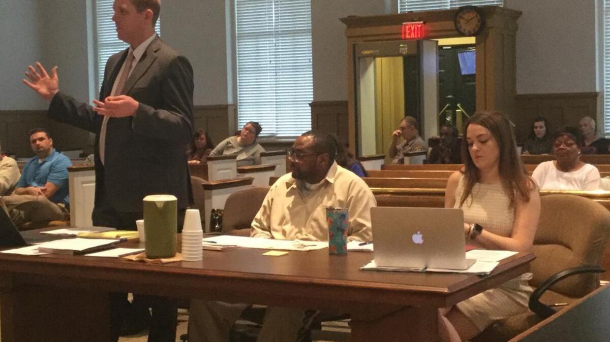 Theodore Harrison Jr., 46, seated center, in court in Chester with his lawyers Monday. Harrison was in court for a resentencing hearing. He is serving consecutive life sentences for two 1988 killings when he was 16 years old.