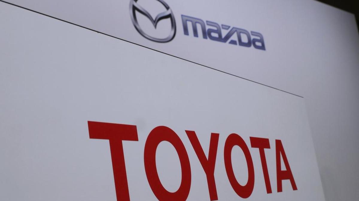 Logos of Toyota Motor Corp., bottom, and Mazda Motor Corp., top, are placed prior to a press conference in Tokyo on Aug. 4.