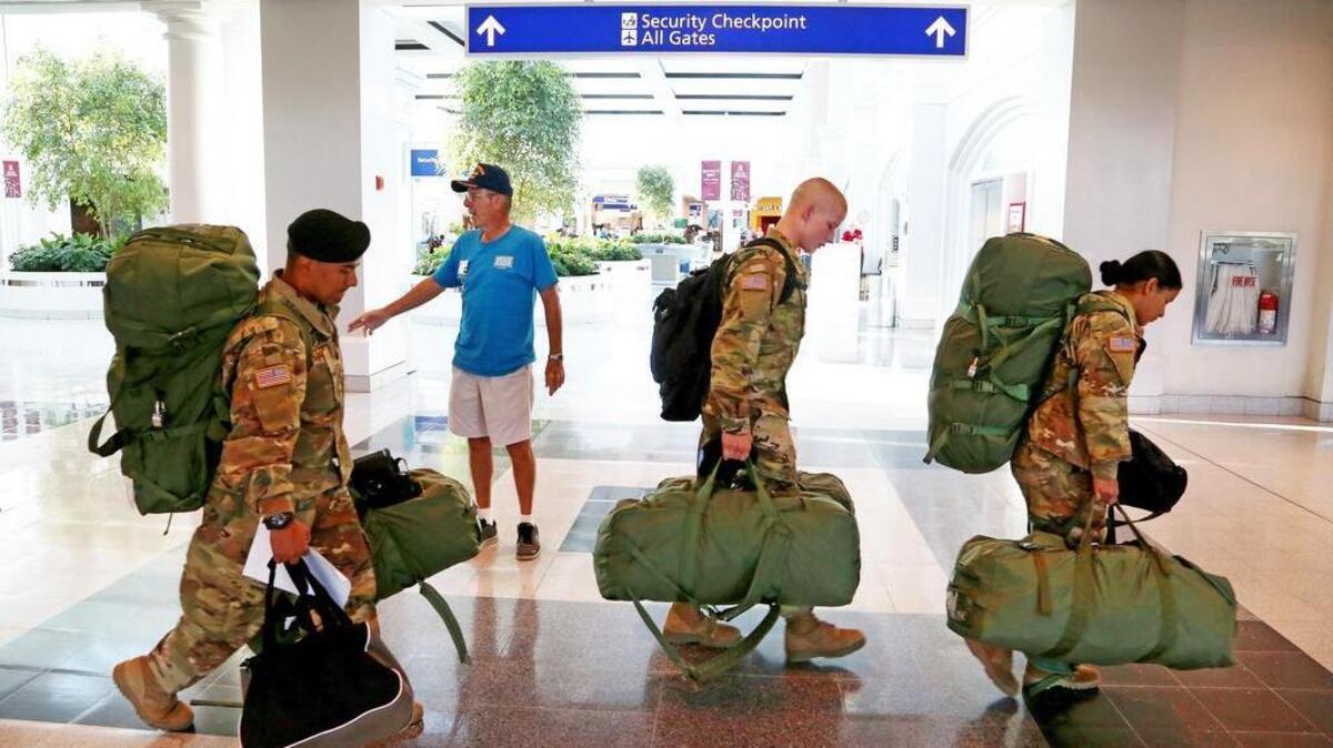 Wayne Yuris, a volunteer with USO, guides Fort Jackson soldiers to the airline check-in area at Columbia Metropolitan Airport last week. The airport says 20 percent of its traffic is related to Fort Jackson.