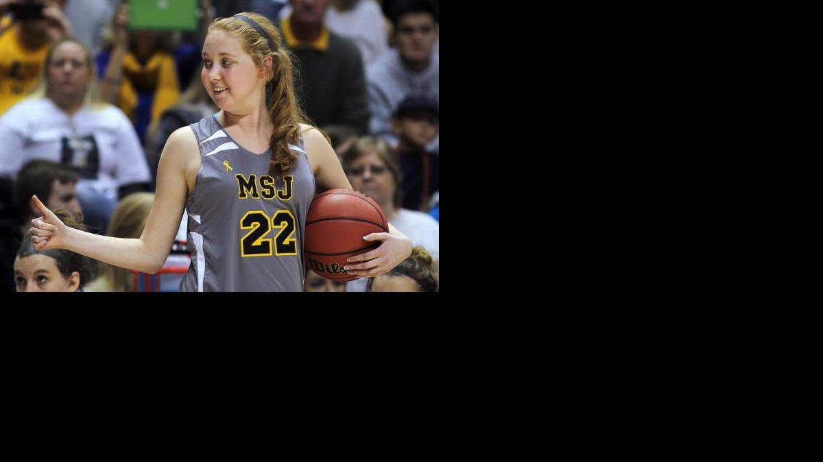 
FILE - In this Nov. 2, 2014, file photo, Mount St. Joseph's Lauren Hill gives a thumbs-up as she holds the game ball during her first NCAA college basketball game, against Hiram University, at Xavier University in Cincinnati. The 19-year-old freshman basketball player died at a hospital in Cincinnati Friday, April 10, 2015, the co-founder of her foundation The Cure Starts Now said. (AP Photo/Tom Uhlman, File)
