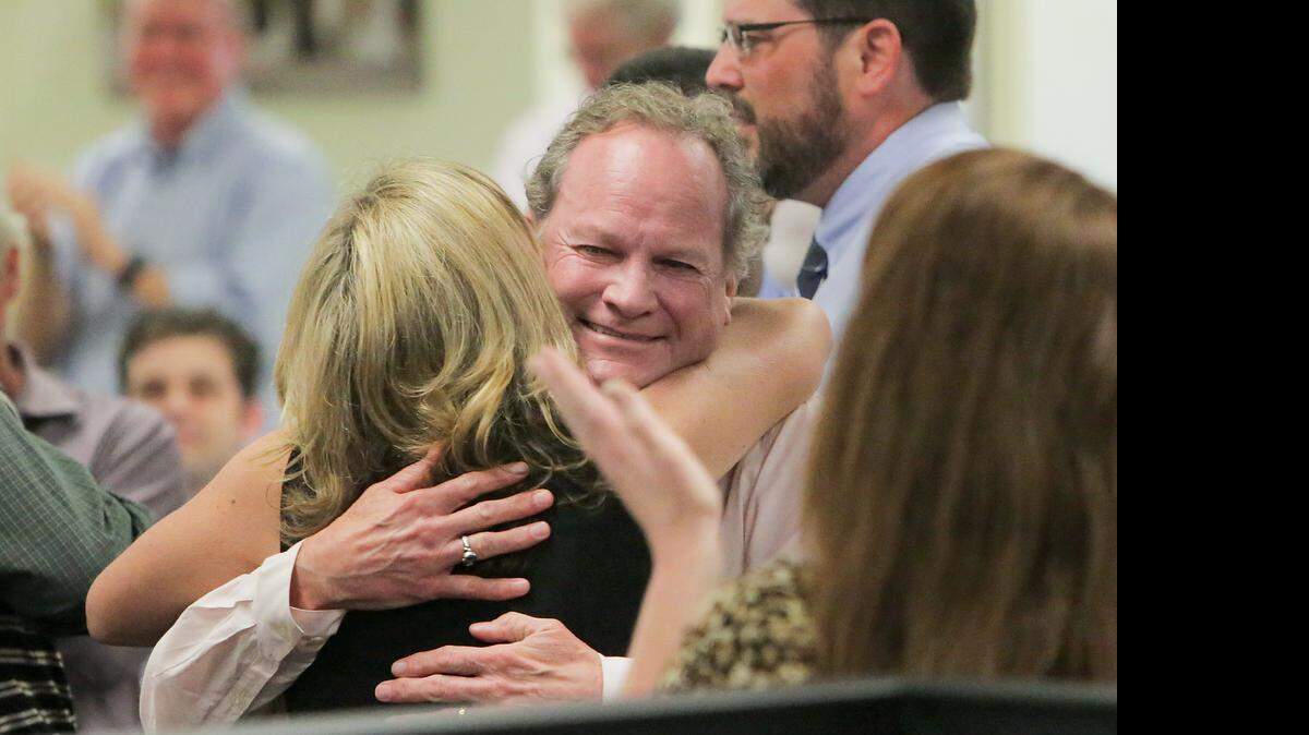 
The Post and Courier reporter Doug Pardue and Publisher P.J. Browning hug after the Pulitzer announcement Monday, April 20, 2015 in Charleston, S.C. The newspaper was awarded a Pulitzer Prize for Public Service for its series on domestic violence. The Public Service gold medal went to reporters Doug Pardue, Glenn Smith, Jennifer Berry Hawes and Natalie Caula Hauff for the series “Till Death Do Us Part.” The series explored the deaths of 300 women in the past decade and a legal system in which abusers face at most 30 days in jail if convicted of attacking a woman, while cruelty to a dog can bring up to five years in prison. 

