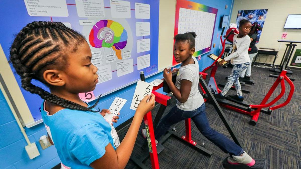 Burton-Pack Elementary third graders Jada Jamison and Edrina Owens take turns quizzing each other on multiplication equations while walking and balancing in a new learning lab this year where kids move while they learn. It’s a test of kinesthetic learning, which takes place when students learn by physical activity rather than sitting and listening to a lecture.