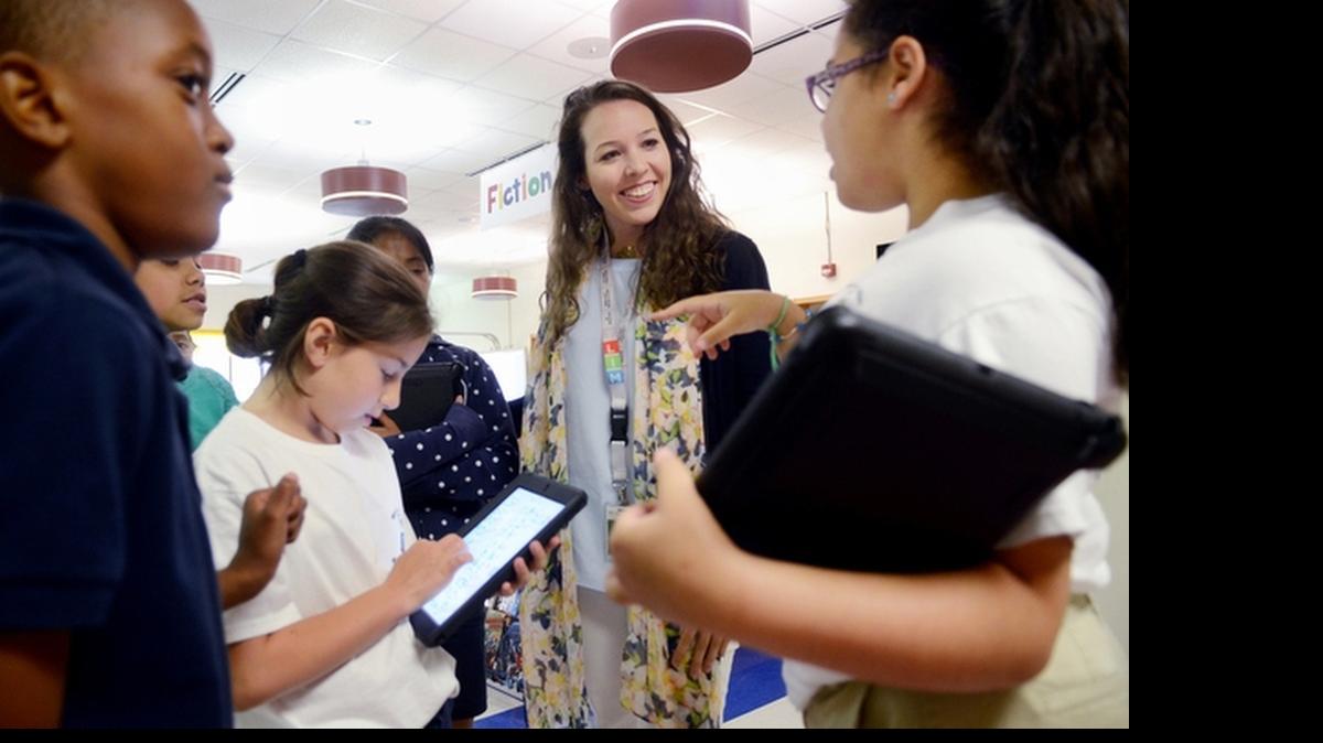 
M.C. Riley Elementary School fourth-grade teacher Banks Summers talks to student Loren Pena following an activity session in the school media center on May 22. 

