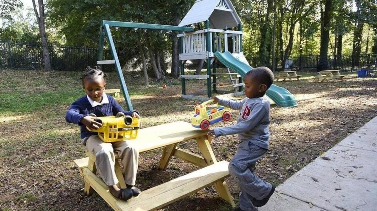 (L-R) Janiya Kempson, 4 and Aubrey Carson, 4, played with trucks during recess but couldn't play on a new playset at The Learning Collaborative. The school recently built a playground with swings, a slide, and mini-climbing wall at their school on Sam Drenan Road. But because of safety regulations the agency needs mulch donated can slide down the slide, swing on the swings and climb to the platform.