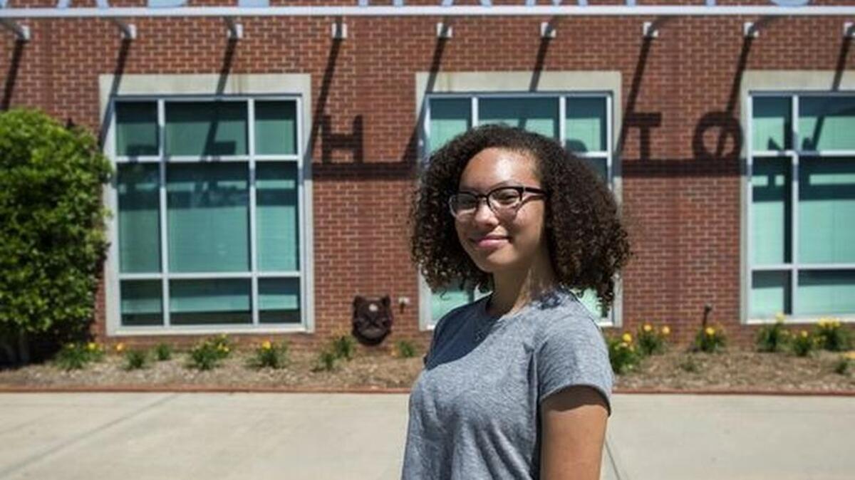 Asha Marie stands in front of the Wade Hampton High School sign earlier this week. She has started a petition to get the school’s name changed.