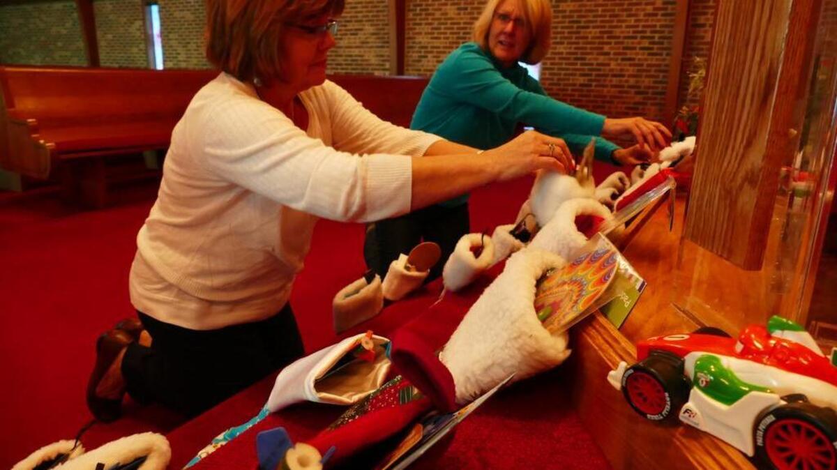 Lynn Elkins, left, and Tammy Bernard help stuff stockings at Woodhaven Baptist Church. Church member Destany Hubbard, 8, wanted to make and stuff stockings for children at Levine Children’s Hospital, and was assisted by church members, family and local businesses.