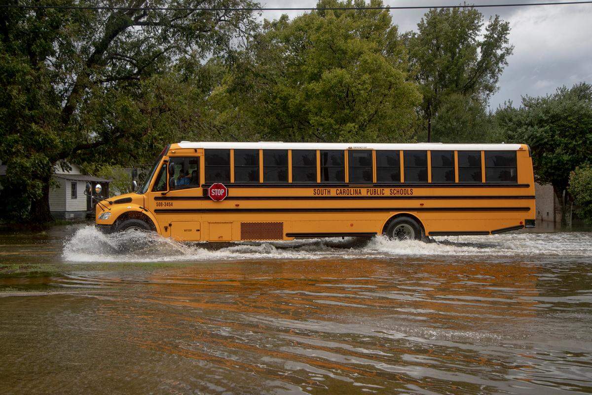 A South Carolina public school bus drives through a flooded street  Sunday Sept. 16, 2018, in Marion, SC. Several Columbia-area law enforcement agencies are accepting supplies and donations to be sent to those affected by flooding from Hurricane Florence.