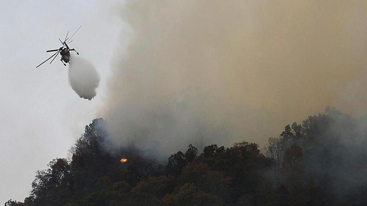Crews work a wildfire near Lake Lure Friday, Nov. 11, 2016. State transportation officials say the wildfire near Lake Lure has forced the immediate closing of U.S. 64/74A and N.C. 9 in Rutherford County.