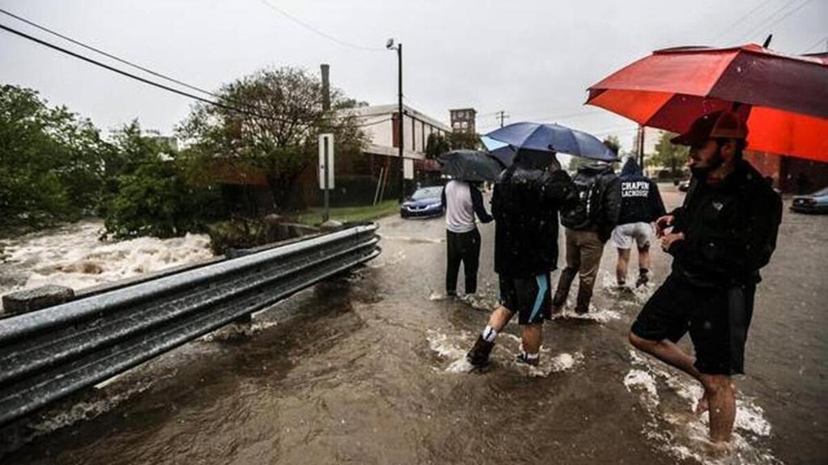 USC students make their way along Catawba Street, near Assembly Street, on April 5. Many downtown Columbia streets flooded that day as a series of storms washed across the Southeast.