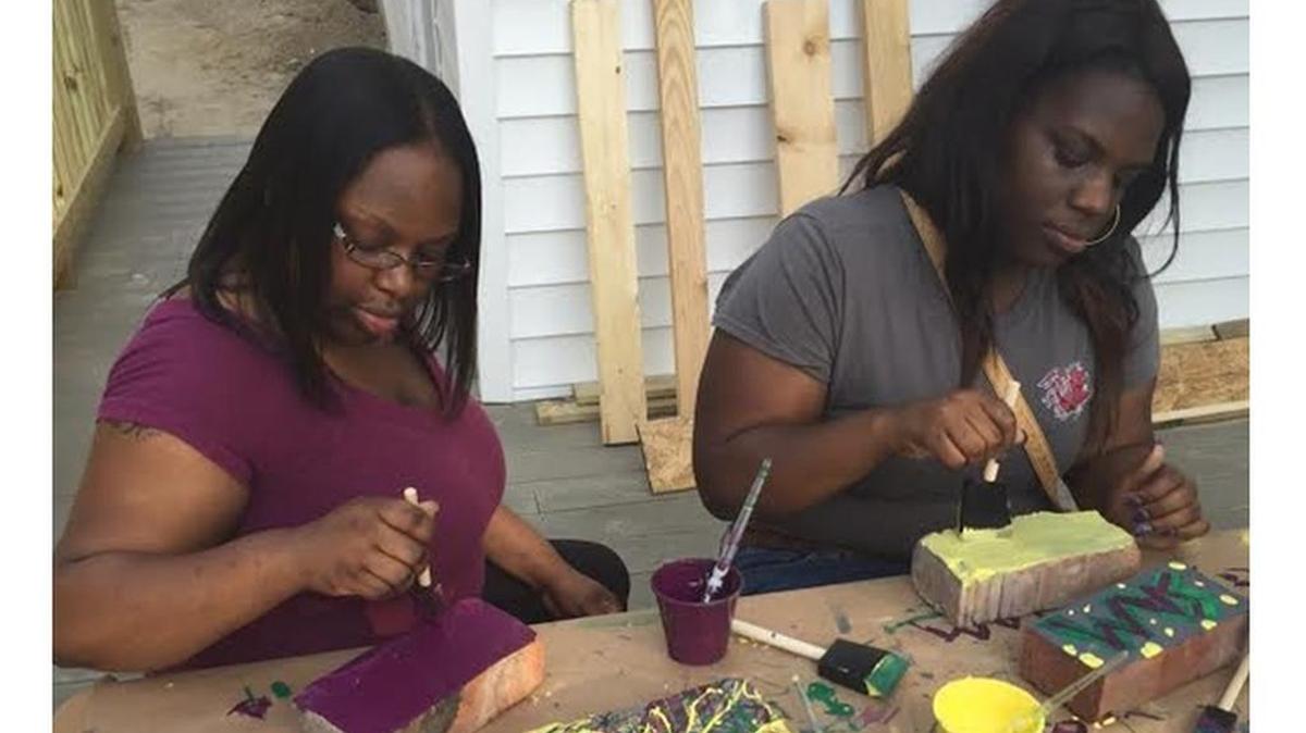 Essence Jackson, a Palmetto Place case manager, and Samantha Favor, a senior at the University of South Carolina, work on a project to make the teens feel at home in the building.