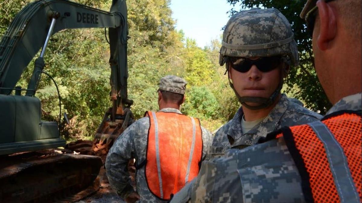 U.S. Army Spc. Joseph Beard, a horizontal construction engineer assigned to the South Carolina National Guard's 124th Engineer Company, 122nd Engineer Battalion, monitors the movements of a hydraulic excavator removing debris on Botanical Parkway in West Columbia, S.C., during a statewide flood response Oct. 14, 2015.