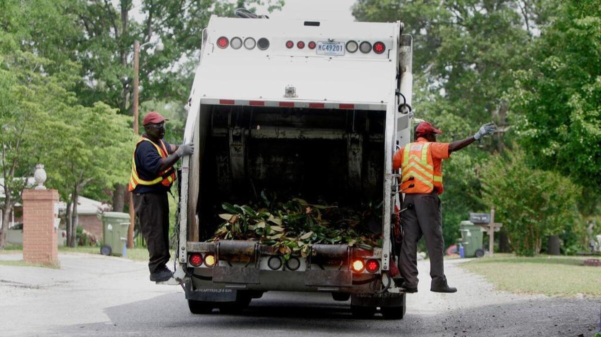 Stevie Glover, left, and Jerome Sheckelford with Cayce Public Works wave to a resident while collecting yard debris Friday in Cayce.