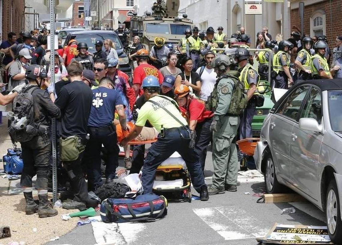 Rescue personnel help injured people after a car ran into a large group of protesters after an white nationalist rally in Charlottesville, Va., Saturday, Aug. 12, 2017. The nationalists were holding the rally to protest plans by the city of Charlottesville to remove a statue of Confederate Gen. Robert E. Lee. There were several hundred protesters marching in a long line when the car drove into a group of them.