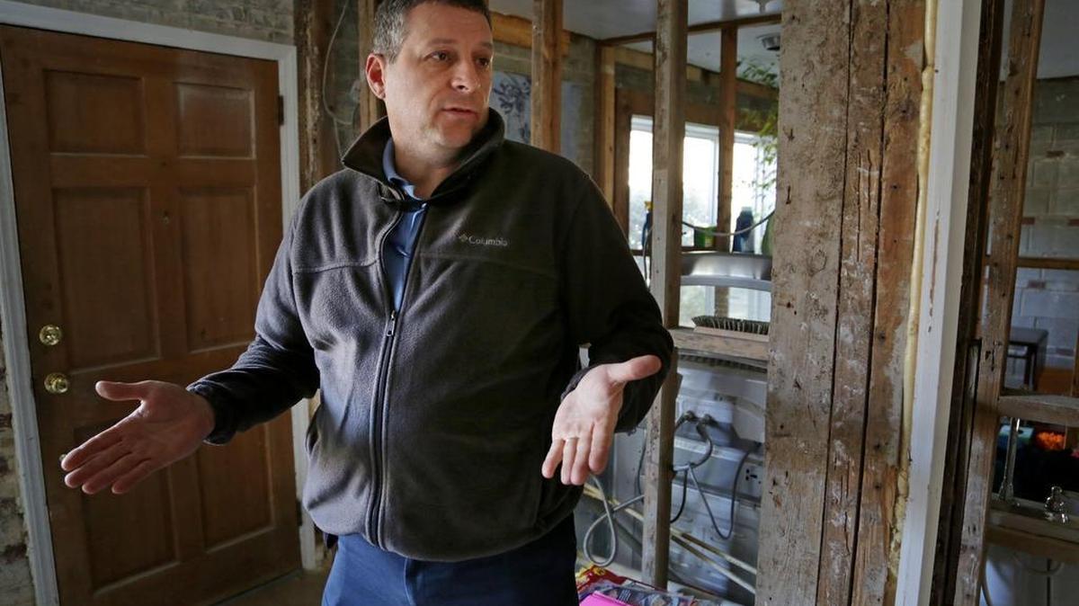 Vince Osborne talks about the damage to his and his wife’s home off South Beltline Boulevard, in which floodwaters rose rapidly and reached the second floor.