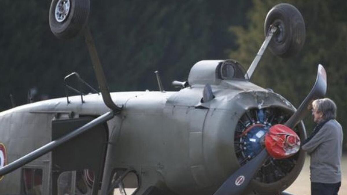 A man takes a look at a French military MH-1521 plane that flipped on a private airstrip in Simpsonville on Tuesday, November 22, 2016.