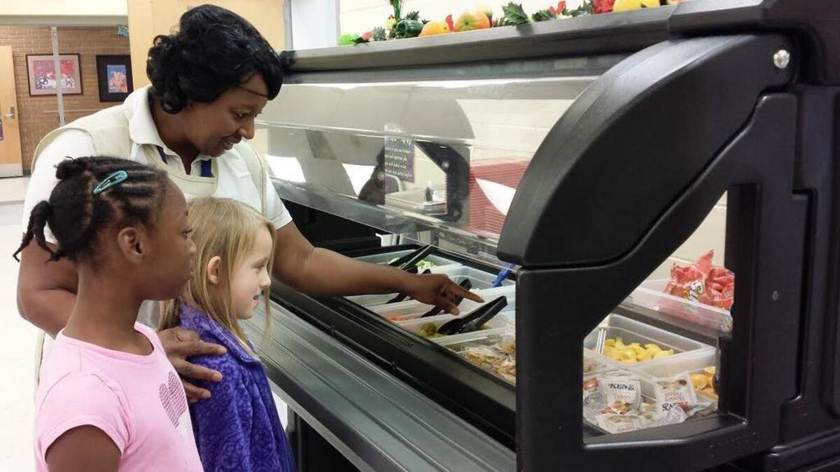 Brockman cafeteria manager Shirleen McCrea shows students the healthy selections in the school’s salad bar.