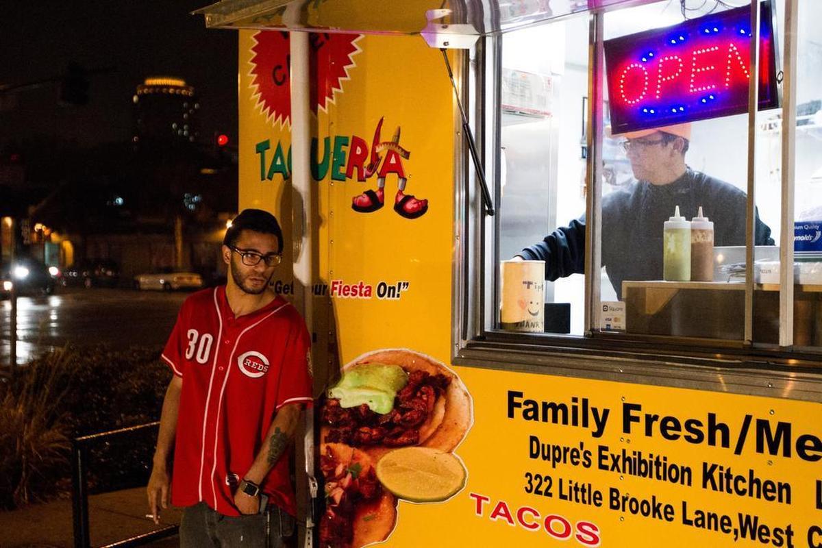 Caleb Brown, a student at Midland Tech, waits for his food as Jesus Ramirez cleans his countertop in his food truck on the corner of Devine and Harden Street.