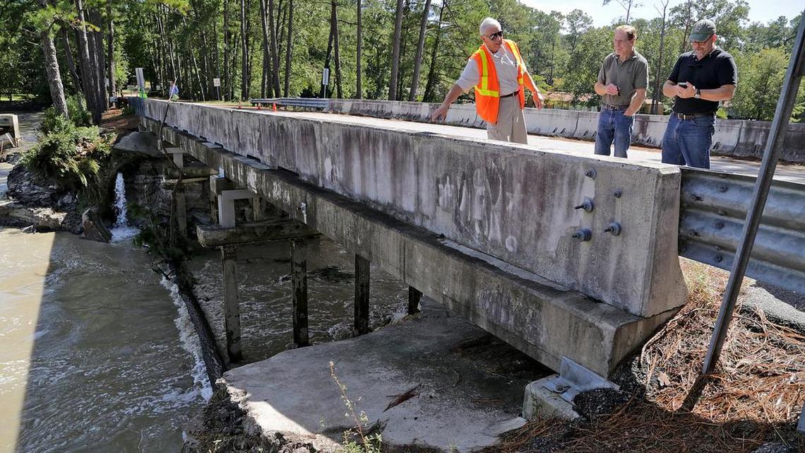From left, Grady Adkins,Todd Chambers and Tom Teuber, president of the Upper Rockyford Lake Homeowners Association, survey the dam at Overcreek Road in Columbia on Oct. 6.