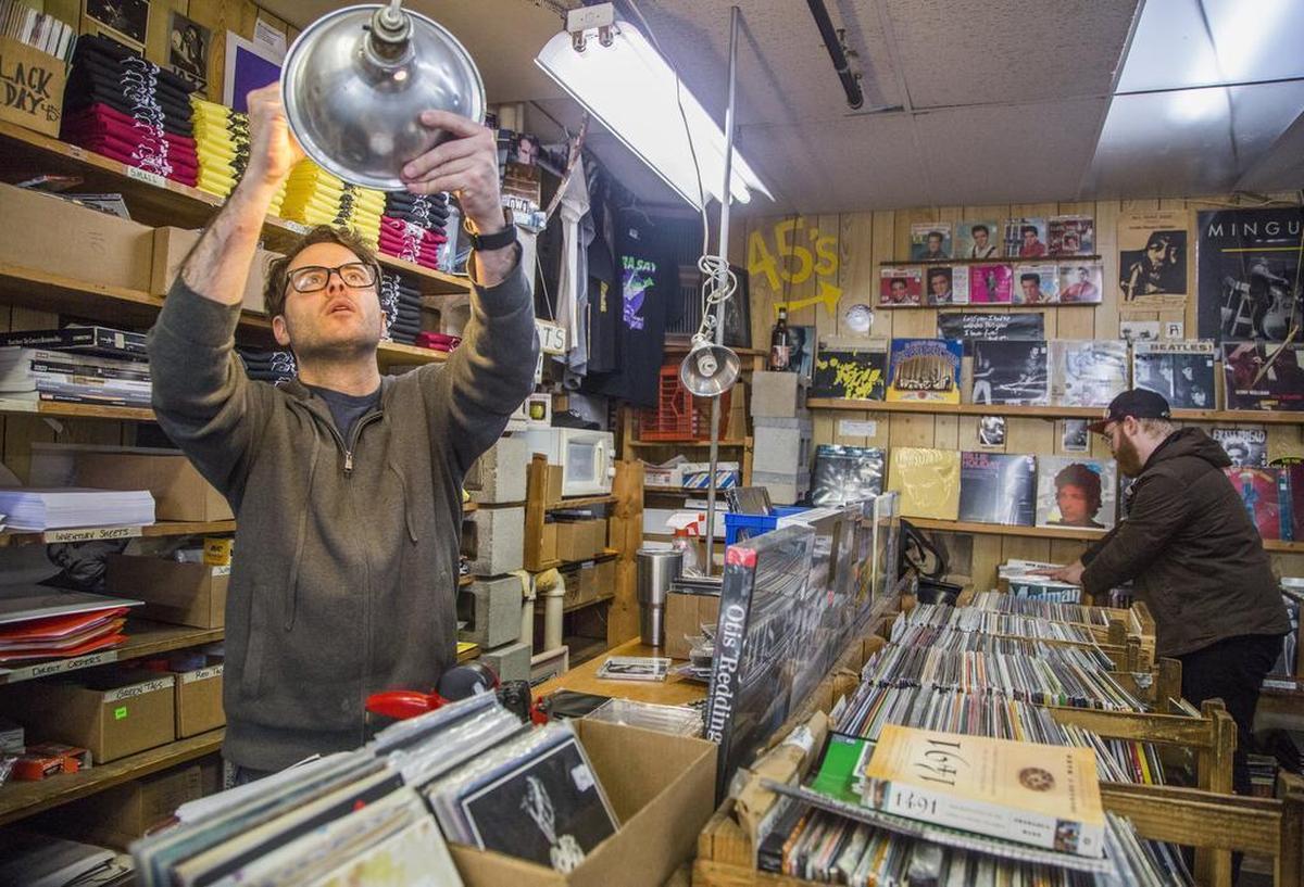 Woody Jones, an employee at Papa Jazz Record Shoppe, examines a used CD in 2018.
