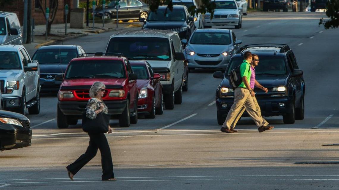 Commuters cross Assembly Street at the intersection with Gervais Street as they arrive for work in downtown Columbia.