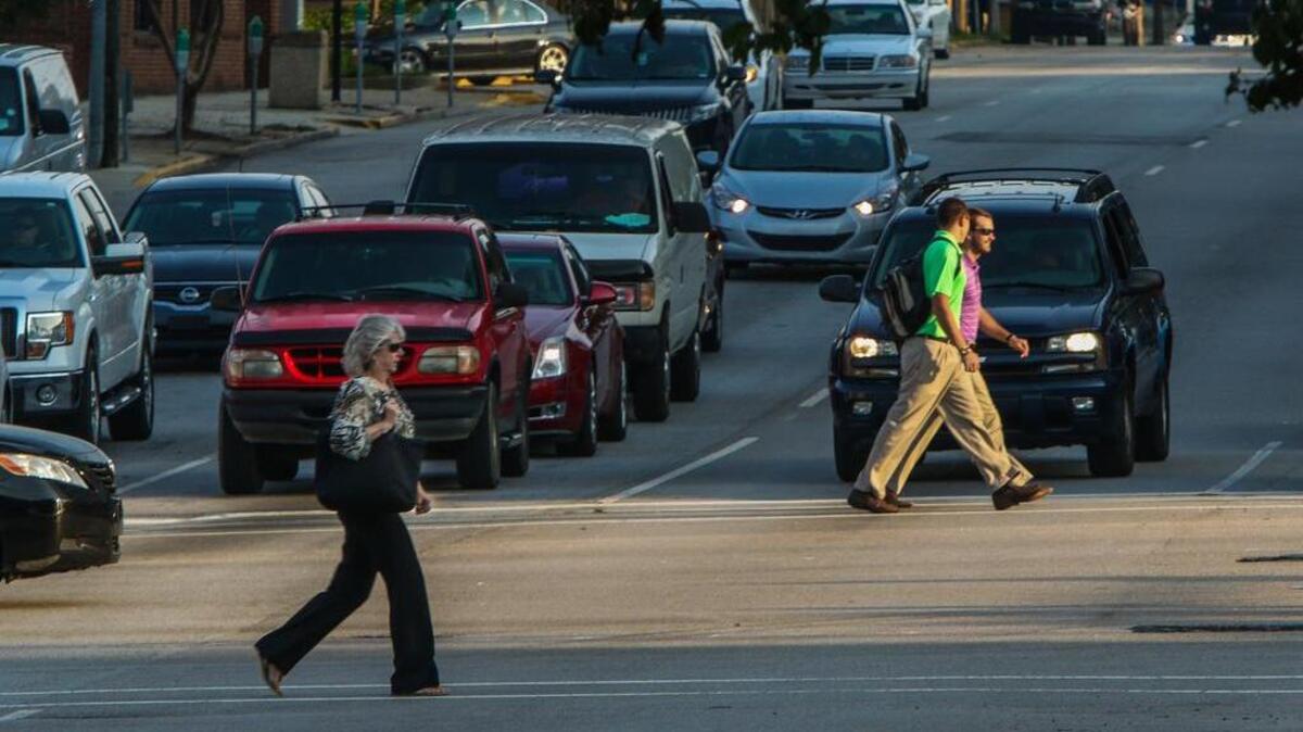 Commuters cross Assembly Street at the intersection with Gervais Street as they arrive for work in downtown Columbia.