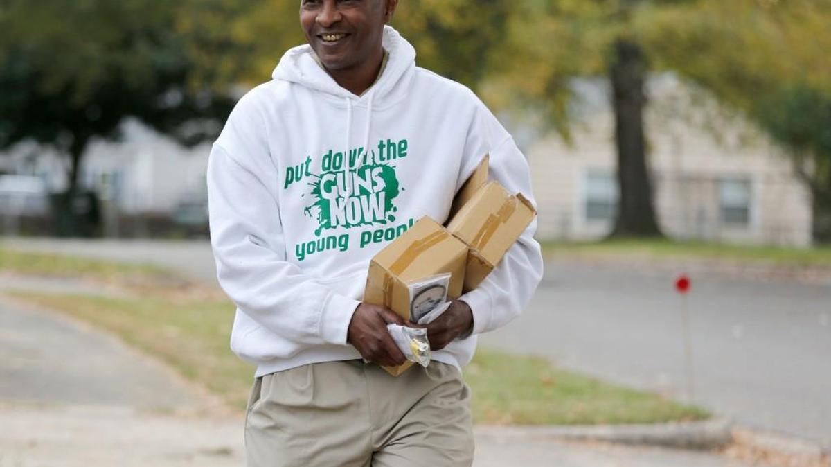 Jack Logan, owner and founder of Put Down the Guns Now Young People, goes door-to-door to hand out gun locks Tuesday on Oconee Ave. in the Rock Hill neighborhood where a 3-year-old boy accidentally shot and killed himself Sunday.
