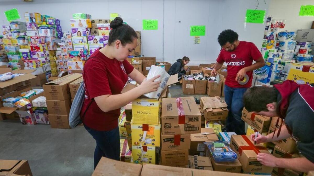USC students Sarah Gibbs, Elizabeth Sawyer, Salvador Cordova and Ryan Preskenis help pack toiletries as Richland County personnel continue the flood relief efforts at the Lower Richland Operations Center and distribution warehouse on Shop Rd.