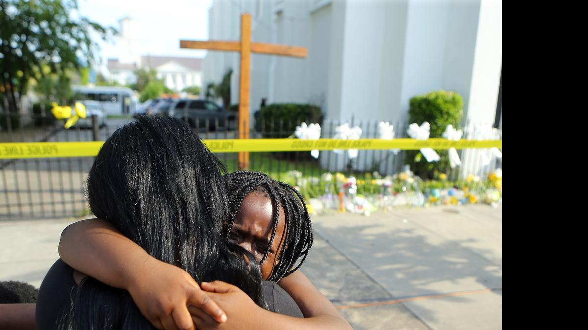 
Kearston Farr hugs her 5-year-old daughter Taliyah visiting a memorial in front of the Emanuel AME Church.
