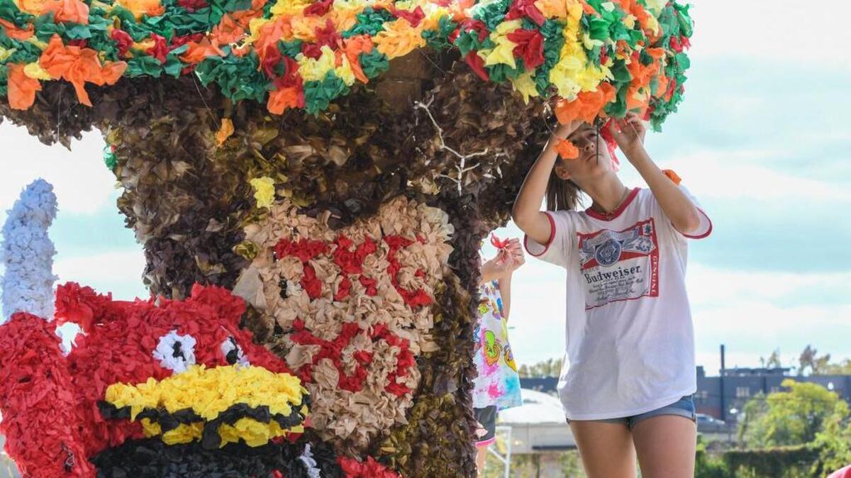 Ali Fuydal strings lights to a tree on a float in preparation for the 2016 USC Homecoming Parade.