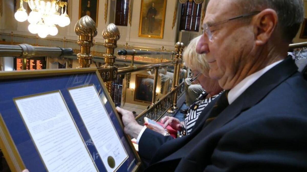 Frank Walker examines the resolution presented to him by the S.C. House of Representatives on Tuesday, honoring him for his actions in Vietnam that saved the lives of six Marines.