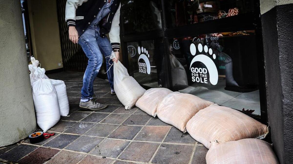 
Kelly Tabor lays down sandbags at Good For The Sole in Five Points. A co-owner of the shoe store on Harden Street called himself a flooding “doomsayer.” Businesses and neighbors in Five Points were preparing for 14 inches of rain forecasted for the weekend.
