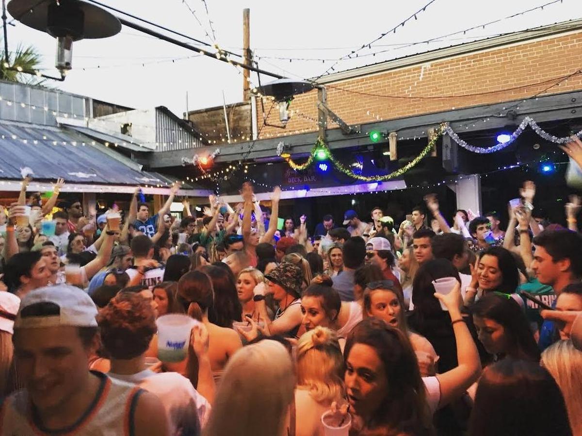 College-aged patrons dance and drink during “Friday After Class” at Group Therapy in Five Points.