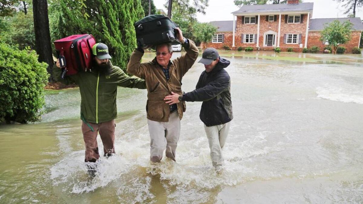 
Mack Leppard, center, is helped by friends, neighbors and volunteers as they retrieve items from his flooded home on Woodlake Drive in Columbia, SC, Monday, October 5, 2015.
