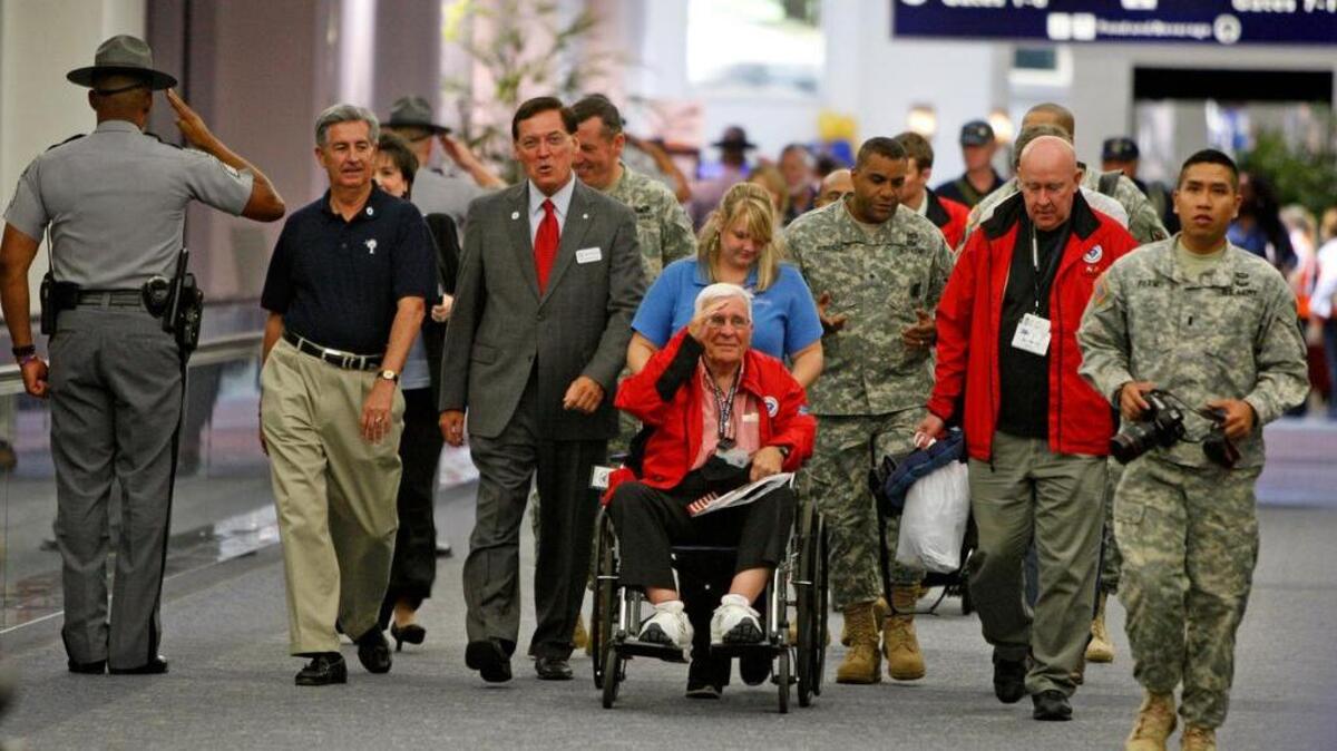 Former state Sen. John Drummond, a World War II pilot, arrives from an Honor flight Wednesday. Drummond received a surprise welcome from Lt. Gov. Glenn McConnell and Senator Nikki Setzler.
