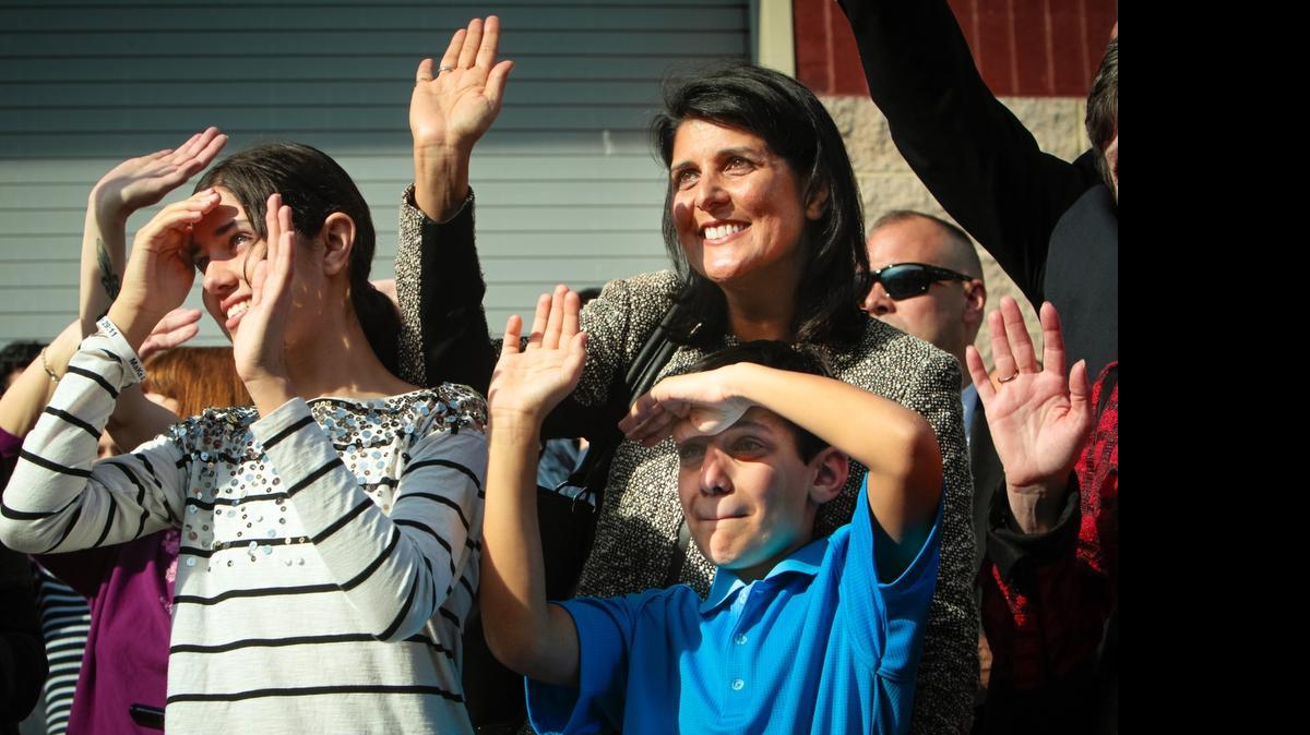 
Gov. Nikki Haley, their son Nalin, 10, and daughter Rena, 14, wave to First Gentleman Michael Haley, as the bus leaves for deployment to Afghanistan  in January 2013. 
