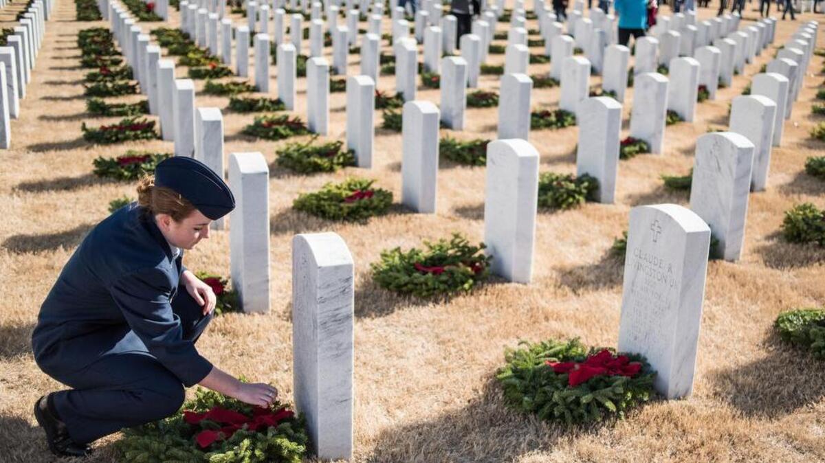 Junior Air Force ROTC member Sierra Dandridge straightens bows on wreaths during the Wreaths Across America ceremony at Fort Jackson National Cemetery Saturday, Dec. 17, 2016, in Columbia, S.C. Approximately 4,500 headstones at the cemetery were dressed with a wreath during one of more than 1,100 ceremonies taking place around the world. December 17, 2016