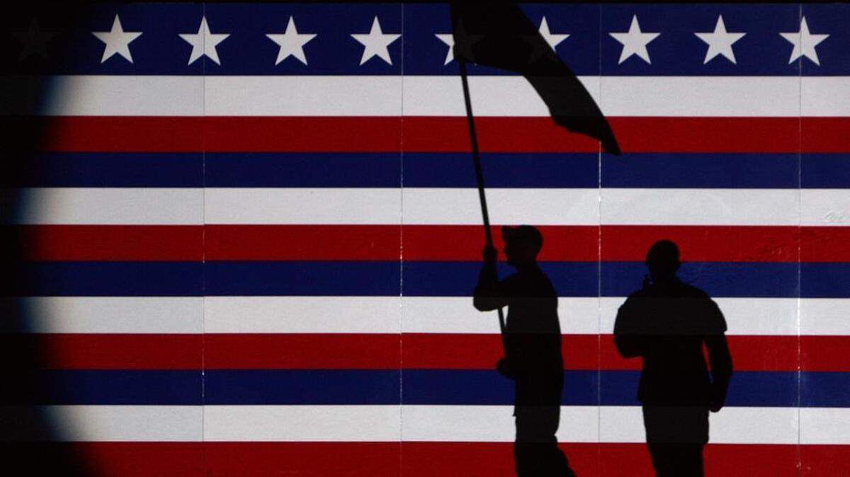 Two soldiers are shadowed against a backdrop during the annual Torchlight Tattoo ceremony that was held at Fort Jackson in 2009.